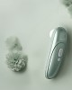 stimulateur clitoridien à air pulsé Womanizer Pro, vert sauge, à côté d'une fleur