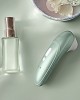 stimulateur clitoridien à air pulsé Womanizer Pro, vert sauge, à côté d'un parfum