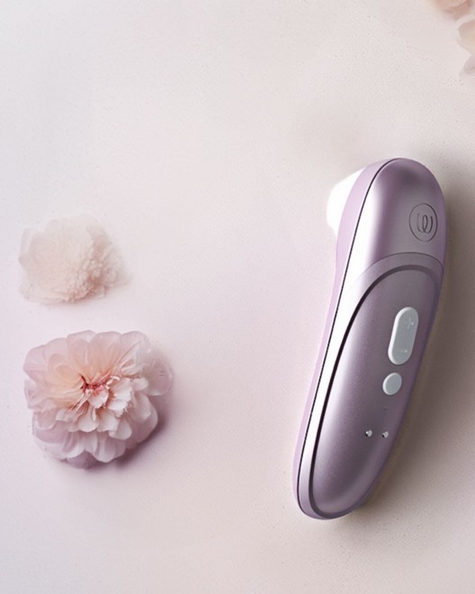 stimulateur clitoridien à air pulsé Womanizer Pro, lilas, à côté d'une fleur