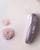 stimulateur clitoridien à air pulsé Womanizer Pro, lilas, à côté d'une fleur