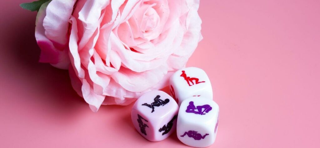 Une rose posée à côté de dés coquins de la marque Secret Play