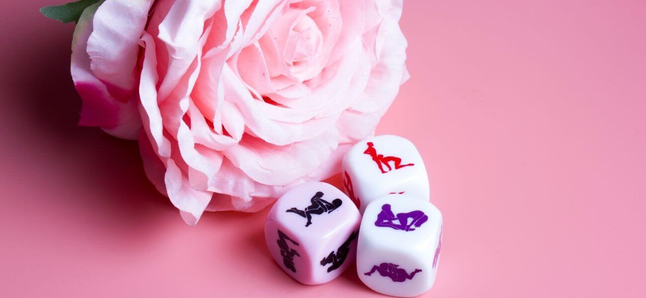 Une rose posée à côté de dés coquins de la marque Secret Play